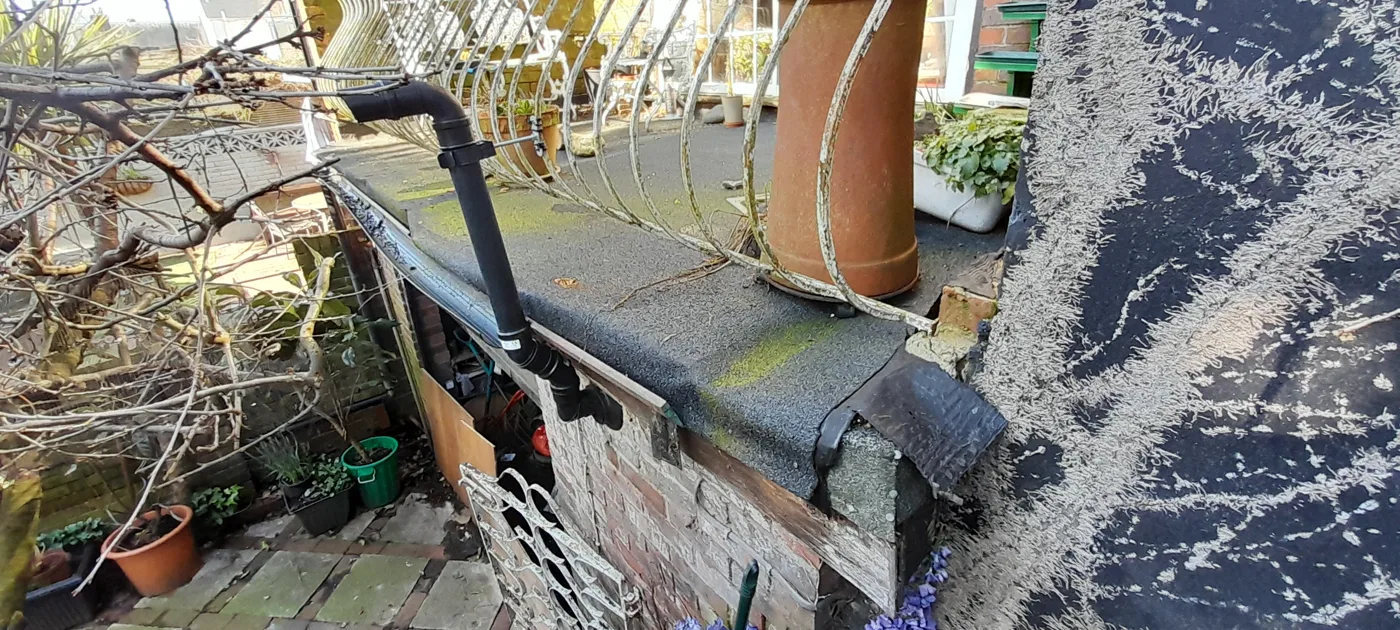 The flat garage roof the homeowner used as a terrace, with plant pots along its edge.